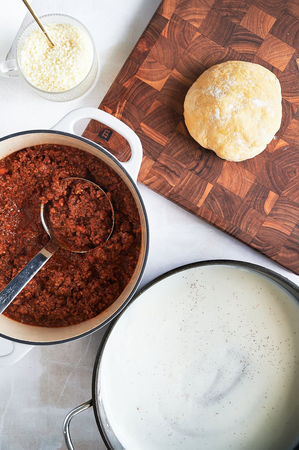 Ingredients for lasagna Bolognese include homemade lasagna dough, pan of Bolognese and bechamel sauces.