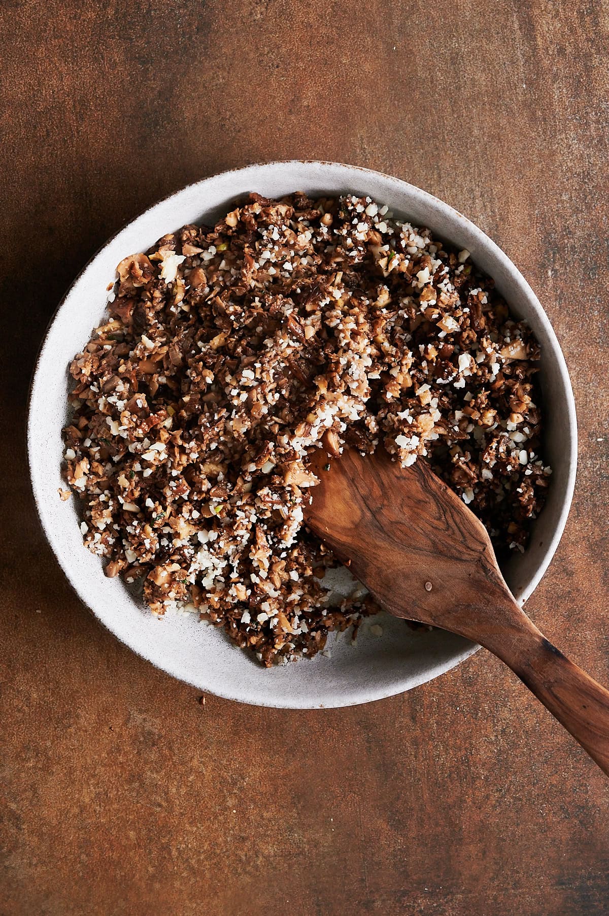 Bowl of cooked mushroom ravioli filling mixed with parmesan cheese.