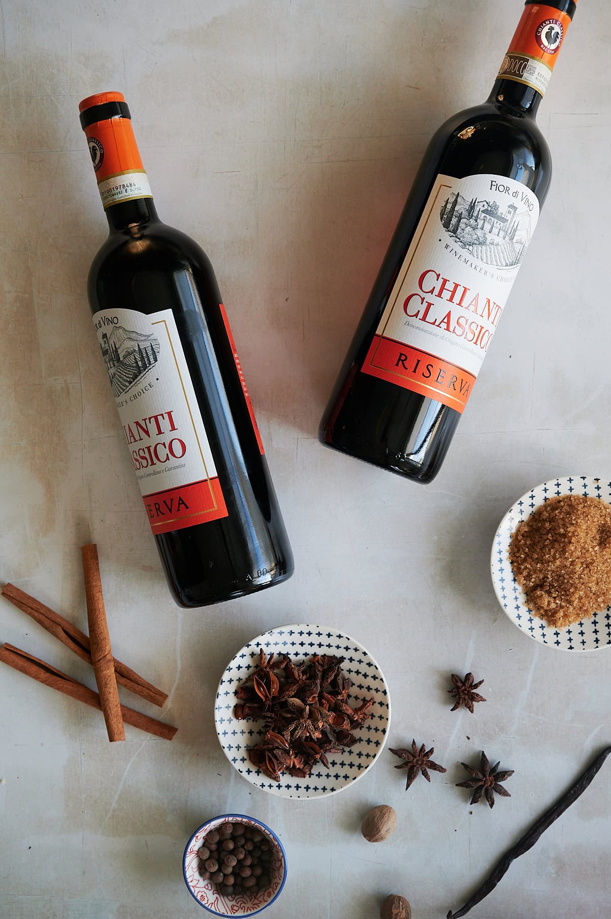 Ingredients for Chianti mulled wine with bowls of star anise, turbinado sugar, star anise and cinnamon sticks.