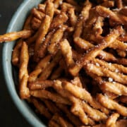 A green bowl of parmesan garlic pretzels close up.