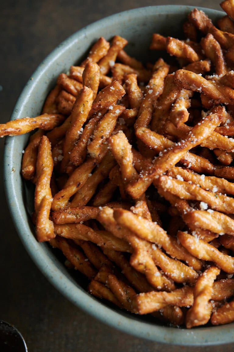 A green bowl of parmesan garlic pretzels close up.