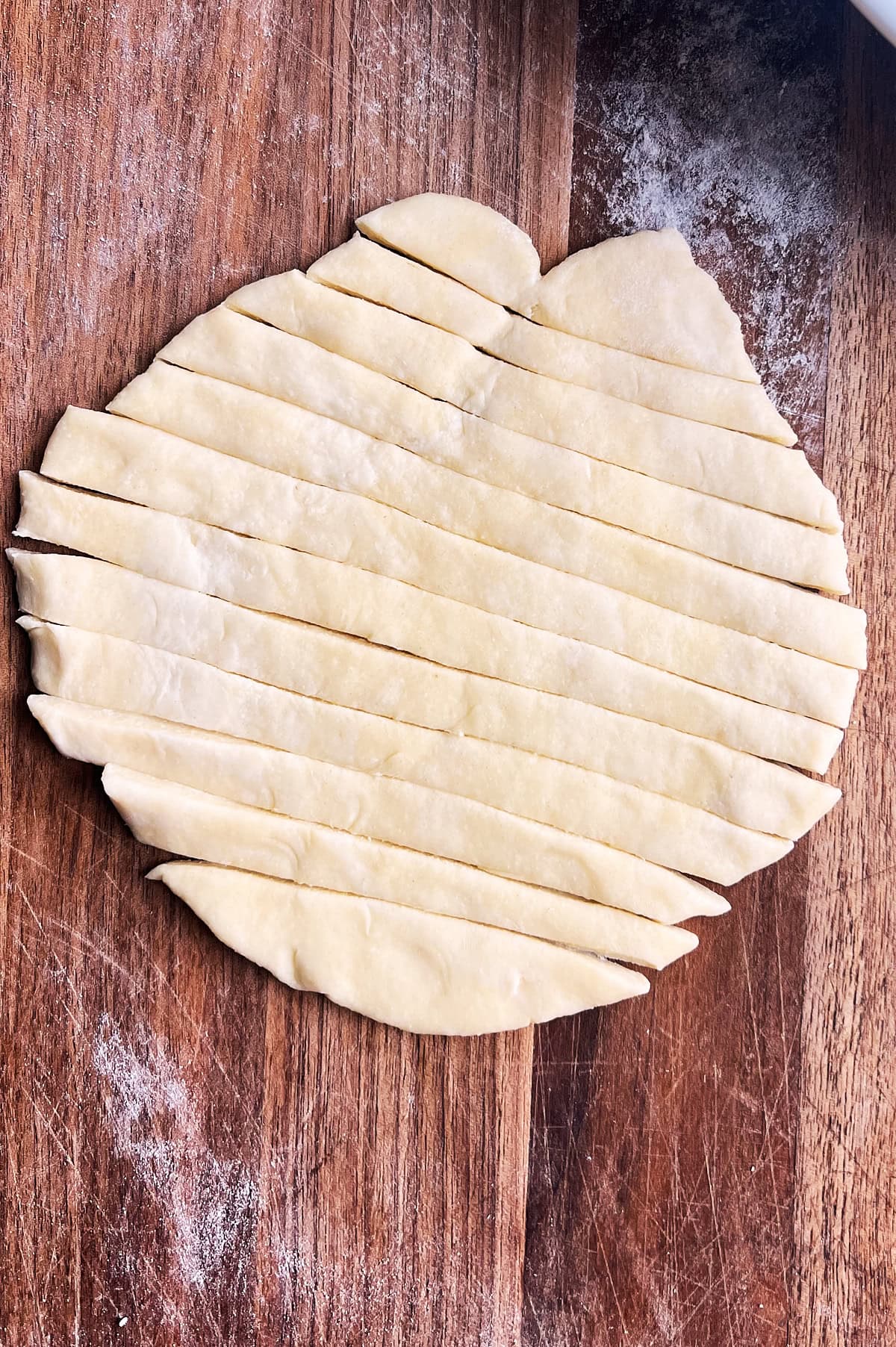 A disk of pasta dough cut into 12 slices for homemade noodles.