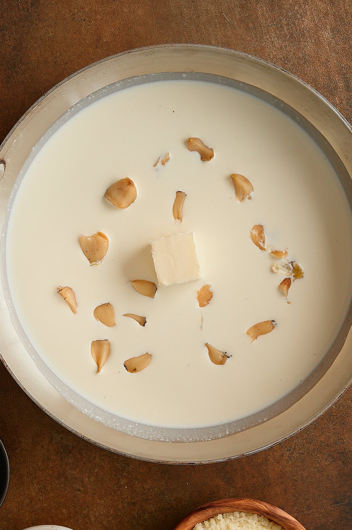 skillet of heavy cream with roasted garlic and butter.