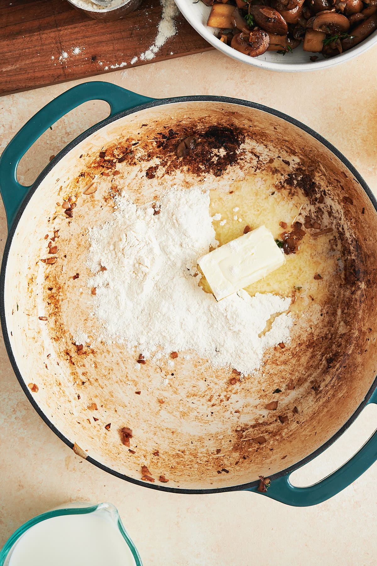 White enamel pan with flour and butter for a roux in mushroom drippings.