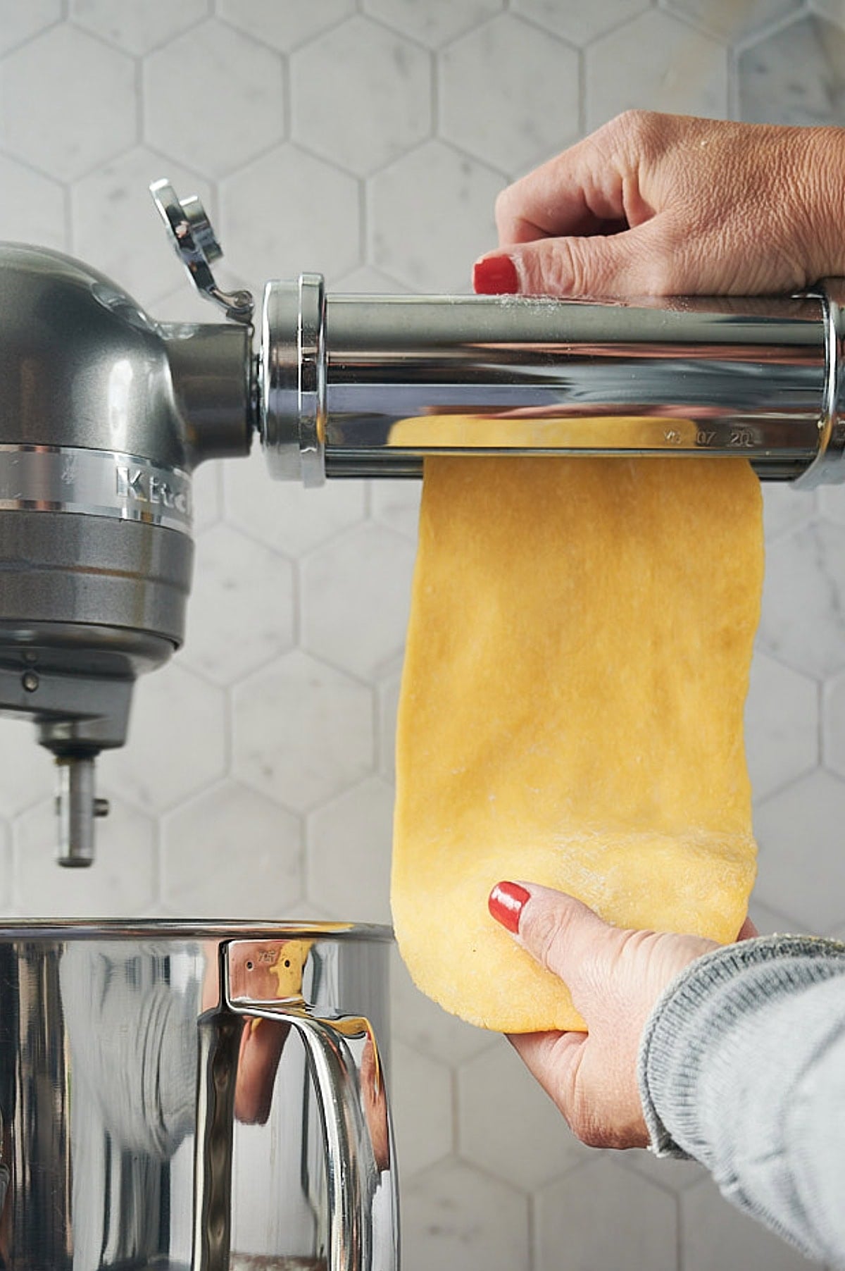 First step of homemade chitarra pasta dough being rolled with a stand mixer pasta attachment.