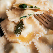 Parmesan cheese topped spinach and cheese ravioli drizzled with butter sauce with sage leaves.