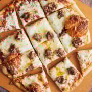 Chicago sausage thin crust pizza cut into squares on a pizza peel.