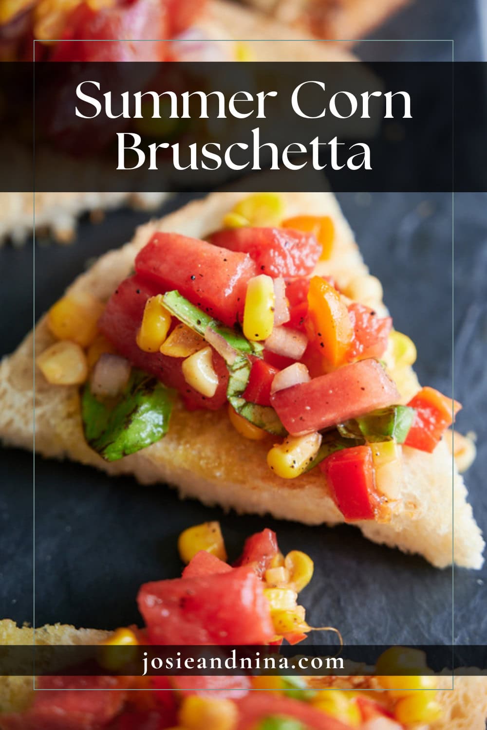 A close-up of summer corn bruschetta topped with corn, tomato, basil, and onions on toasted bread, displayed on a dark surface.