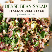 A bowl of Italian deli-style bean salad with chopped greens, beans, olives, and vegetables, topped with a label reading Dense Bean Salad Italian Deli Style.