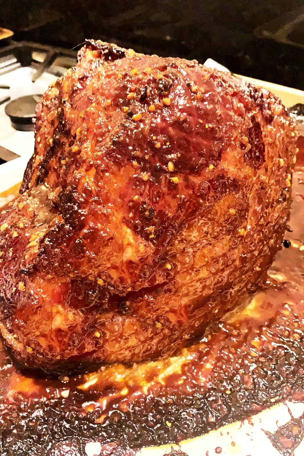 baked glazed ham on sheet pan with charred glaze.